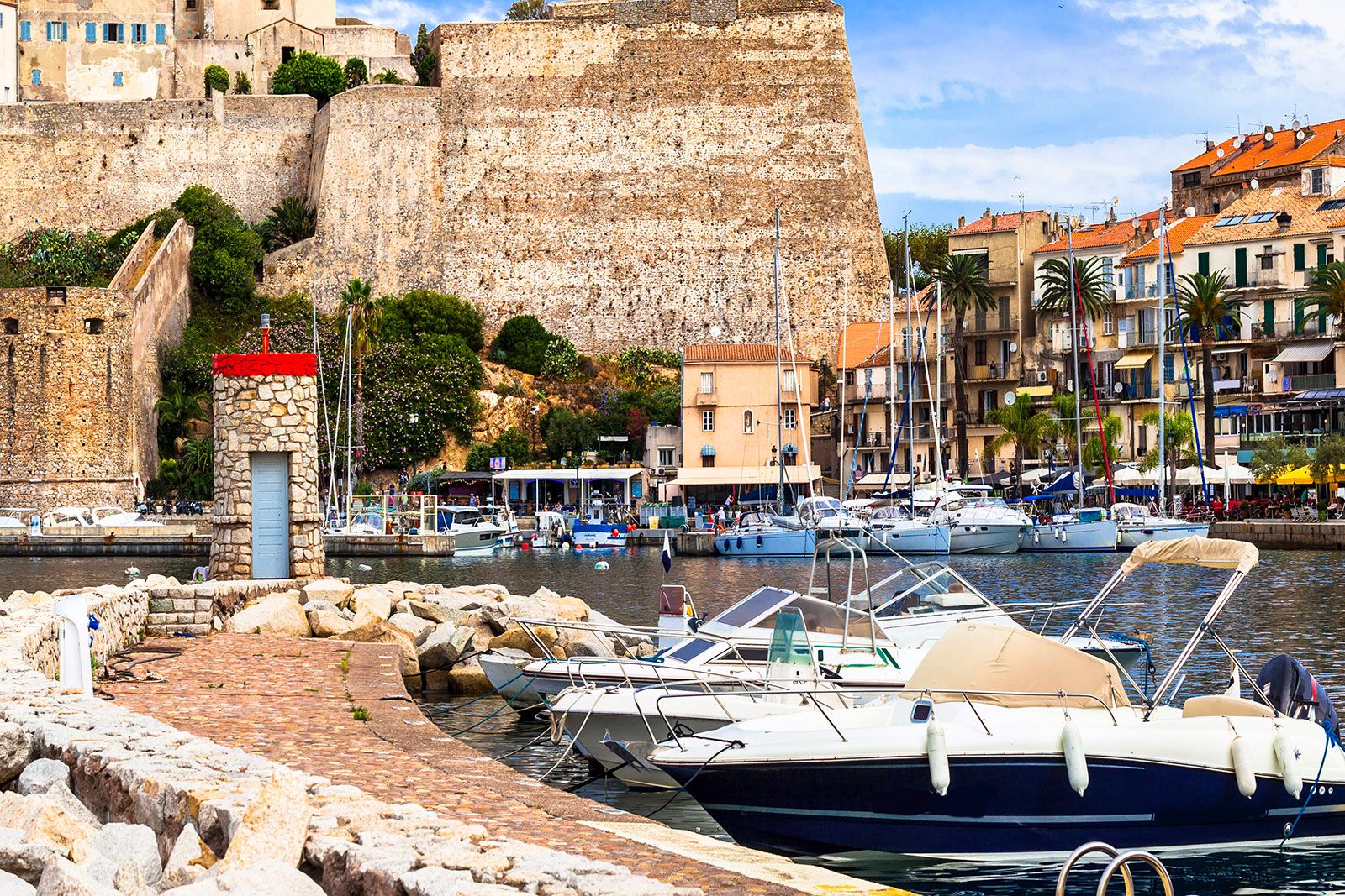Harbor scene with boats and a castle-like building in the background