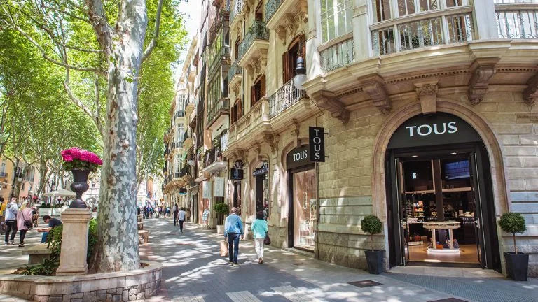 Street scene with a building featuring a TOUS store entrance.
